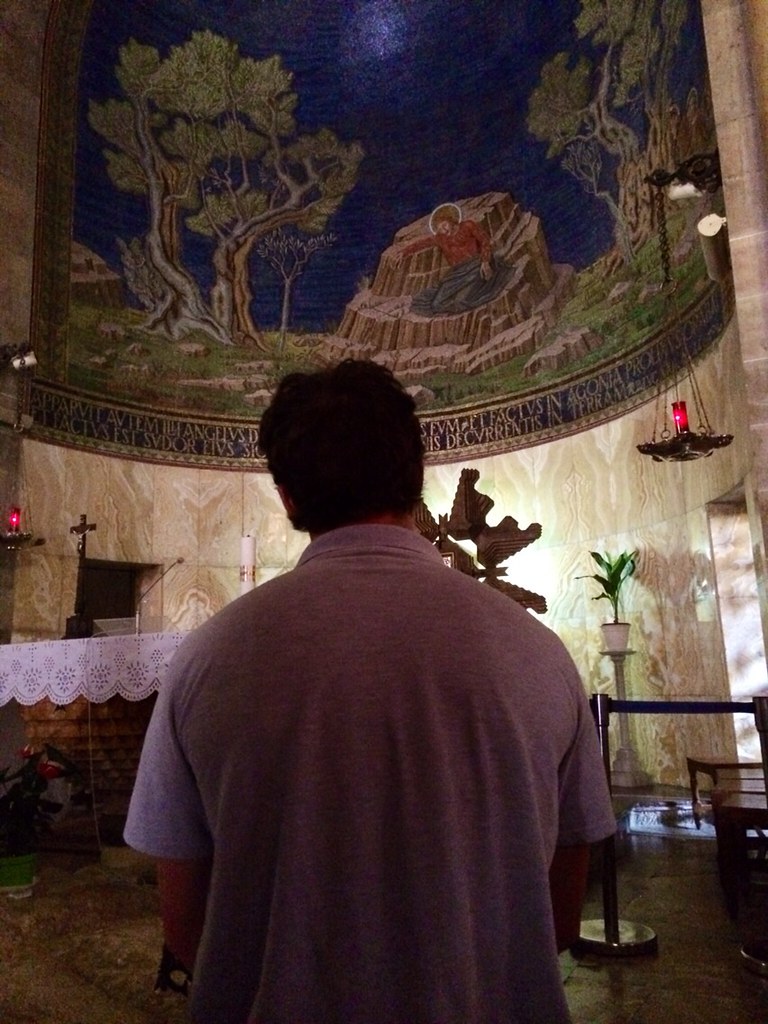 Marcos Pou de espaldas, orando ante el mosaico de la agonía de Jesús en la basílica de Getsemaní