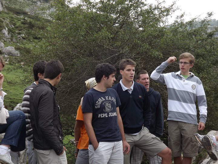 Grupo de jóvenes conversando al aire libre en un paisaje de montaña durante una excursión