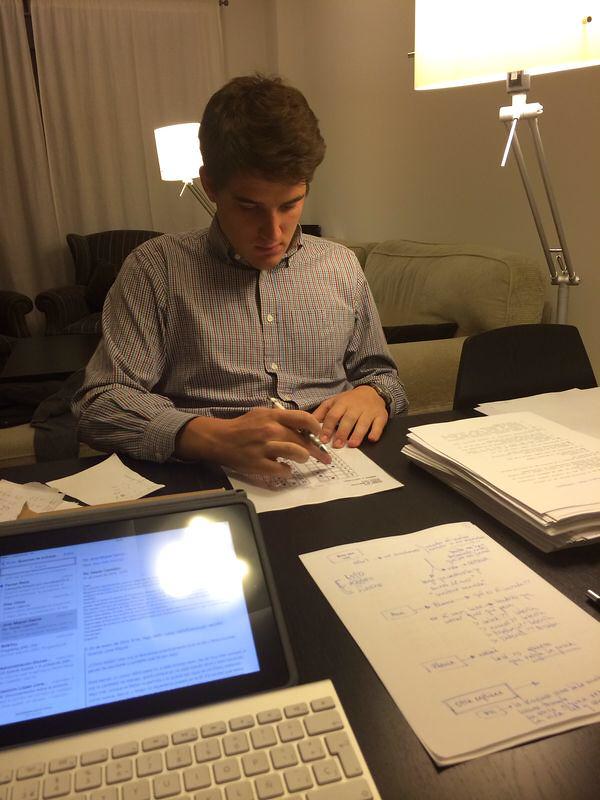 Marcos Pou estudiando en casa, con apuntes manuscritos sobre la mesa y un portátil abierto junto a él