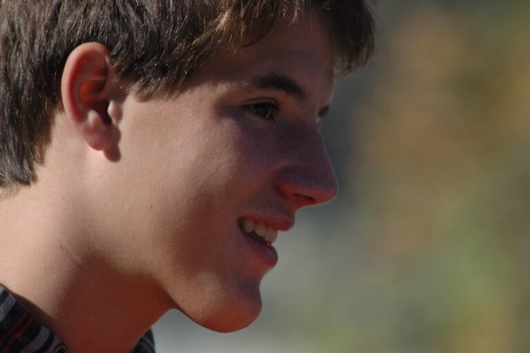 Primer plano de perfil de Marcos Pou sonriendo al aire libre, con el fondo desenfocado