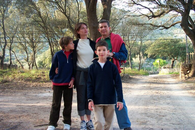 Marcos Pou de niño con dos adultos y otro niño en un camino de tierra entre árboles durante una excursión