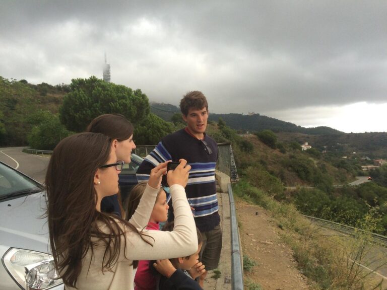 Marcos Pou con un grupo de jóvenes y niños en un mirador de la sierra de Collserola, haciendo fotos junto a un coche