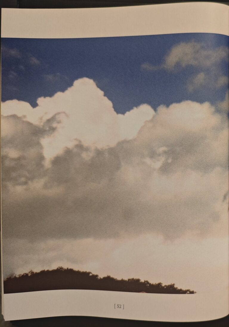 Page 52 of the catalogue: blue sky with clouds over a hill