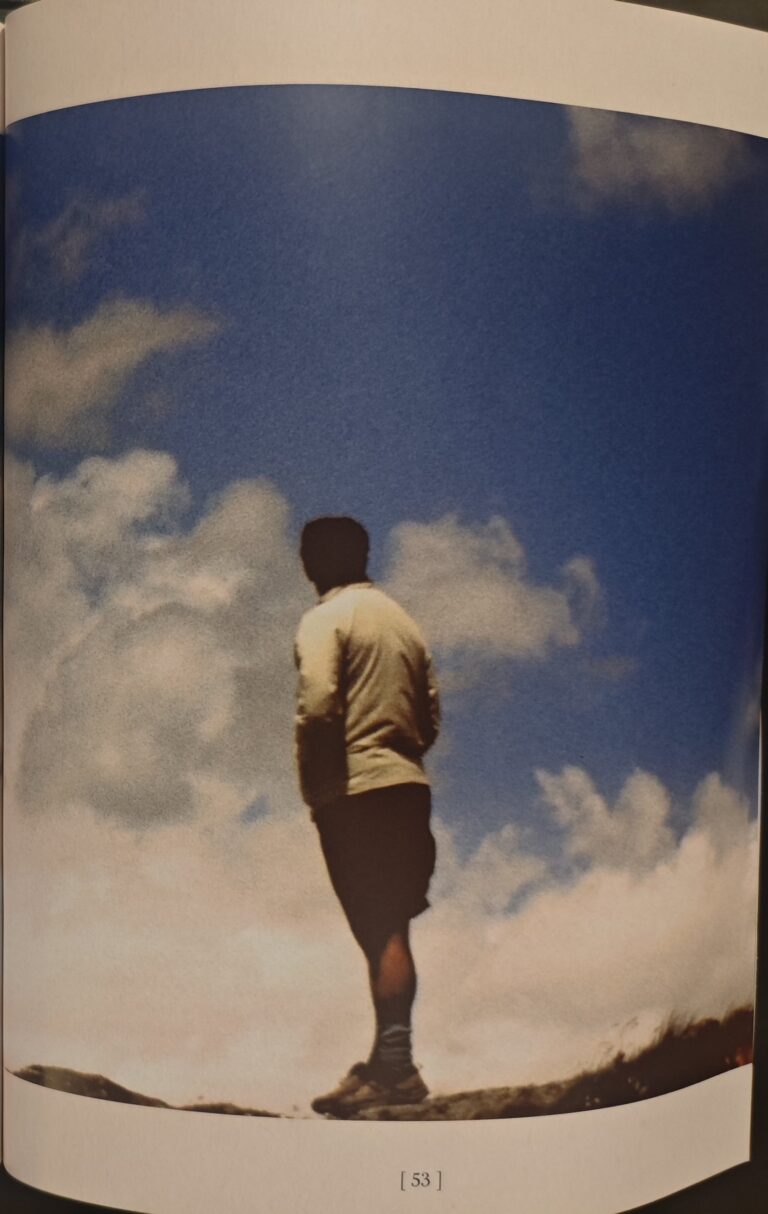 Page 53 of the catalogue: Marcos standing with his back turned, on top of a hill, looking at the sky